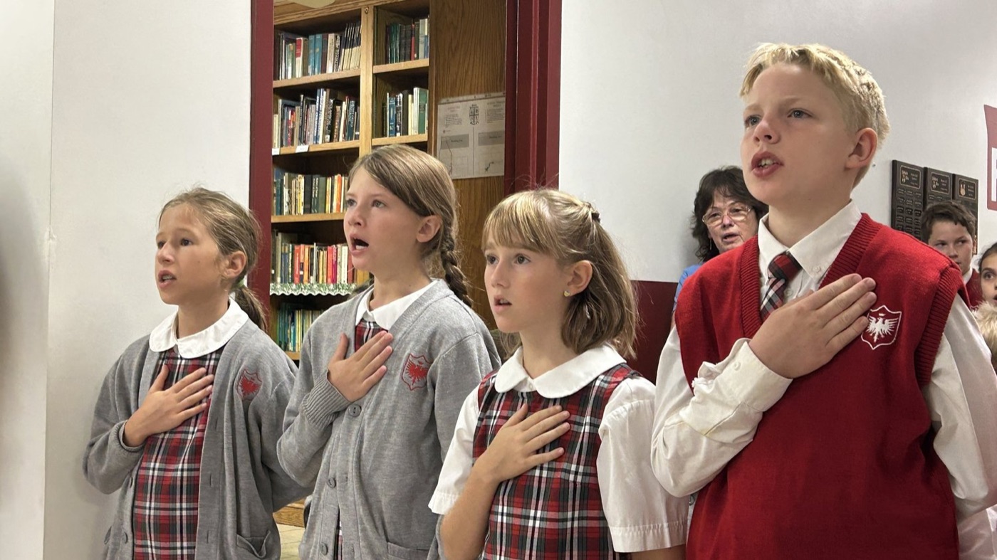 Students say the pledge at St. Peregrine Academy’s Charter Day