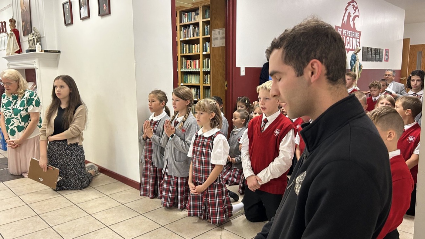Students pray at St. Peregrine Academy’s Charter Day