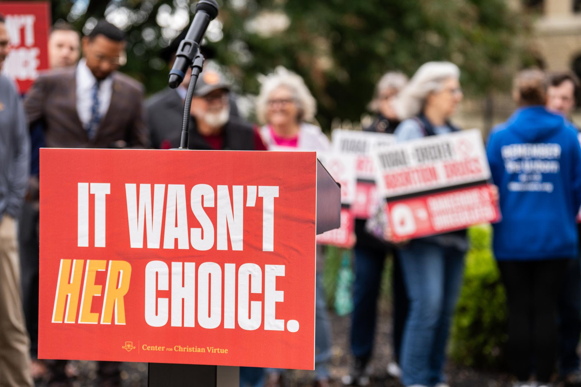 An “It wasn’t her choice” sign on the podium at the Lucas County Courthouse